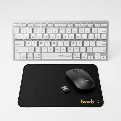 A wireless computer setup on a light gray background, featuring a silver mini keyboard, a black mouse with the brand name 'Anxin' printed on it, and a black mousepad with the brand name 'farah' printed in yellow.